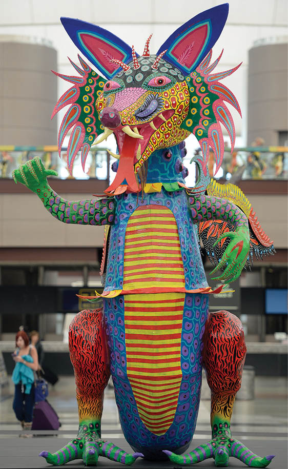 DENVER, CO - MARCH 20:   The giant Alebrije on display at Denver International Airport on Thursday March 22, 2014  The alebrije was created by Óscar Becerra-Mora, one of Mexico s great contemporary artists  He has dedicated more than 10 years to the art of cartonería: vibrantly painted papier-mâché sculptures incorporating modeled cardboard  Xólotl: Dios Perro (Xolotl: Dog Deity) showcases Becerra-Mora s mastery of cartonería, and is his take on a mythological creature from the Aztec culture   Xólotl: Dios Perro is the first monumental alebrije that has ever been on display in the United States   Xólotl first came to Denver as part of the 2013 Biennial of the Americas celebration, and is now on display at the Denver International Airport s Jeppesen Terminal until May, 2014  ( Photo by Cyrus McCrimmon)
