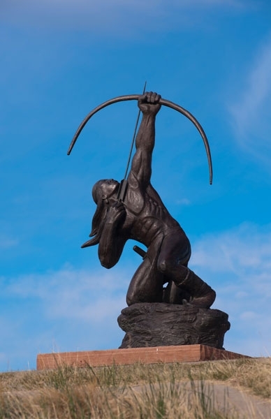 Sculpture of man shooting arrow into the air