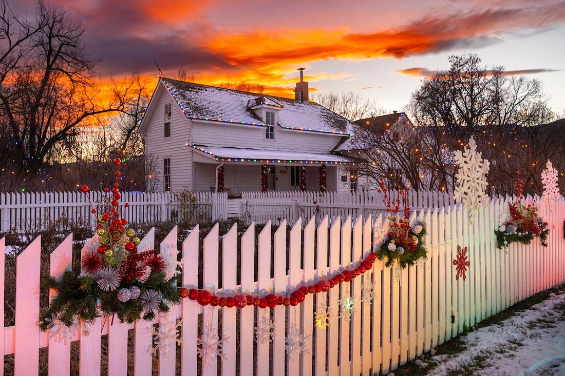 White house and picket fence decorated for Christmas