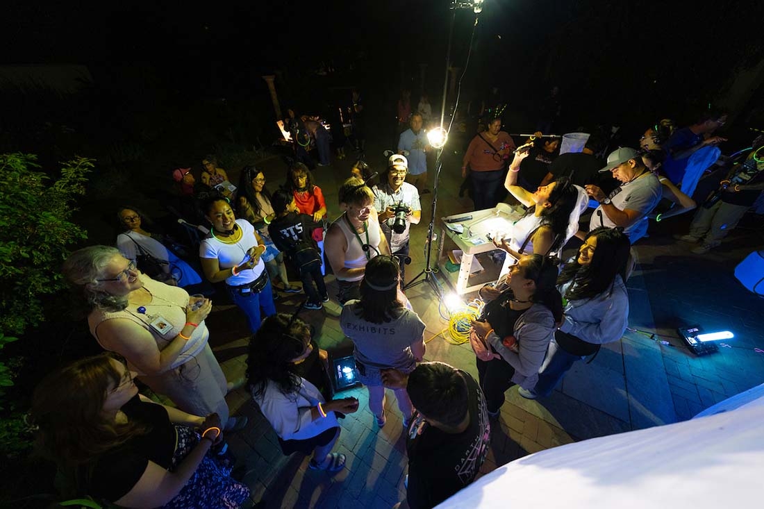 Group of people at night looking at insects