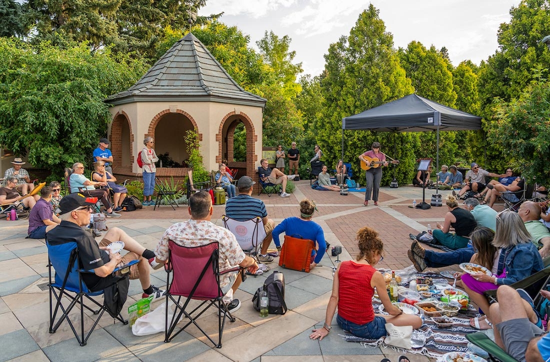 Crowd listening to a guitarist playing outside in the Romantic Gardens