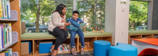 Adult and child reading in the Helen Fowler Library