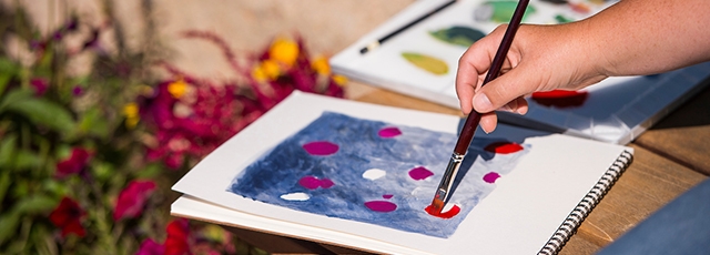 Child painting flowers using watercolors