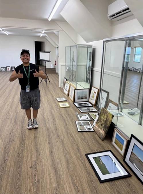 Person giving thumbs up by artwork