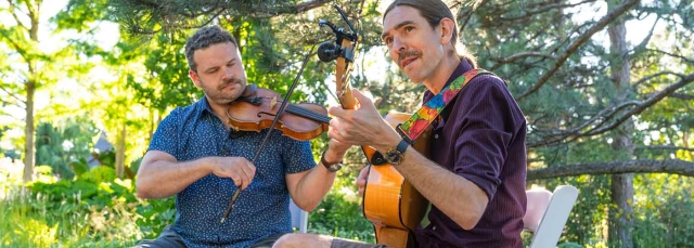 Two Evenings al Fresco musicians outside playing a guitar and a violin