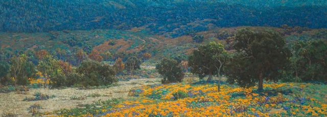 A field of orange poppies in the foreground with trees behind them. Mountains are in the background.